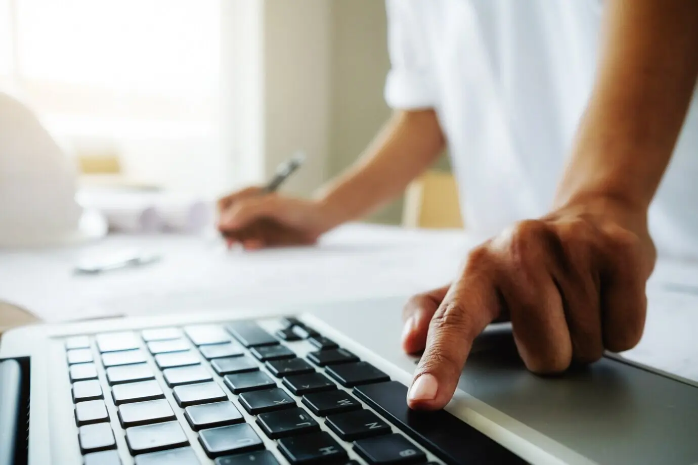 Hände eines Ingenieurs, der an einem Bauplan arbeitet; Baukonzept. Ingenieurwerkzeuge. Vintage-Farbton mit Retro-Filtereffekt, weicher Fokus (selektiver Fokus).